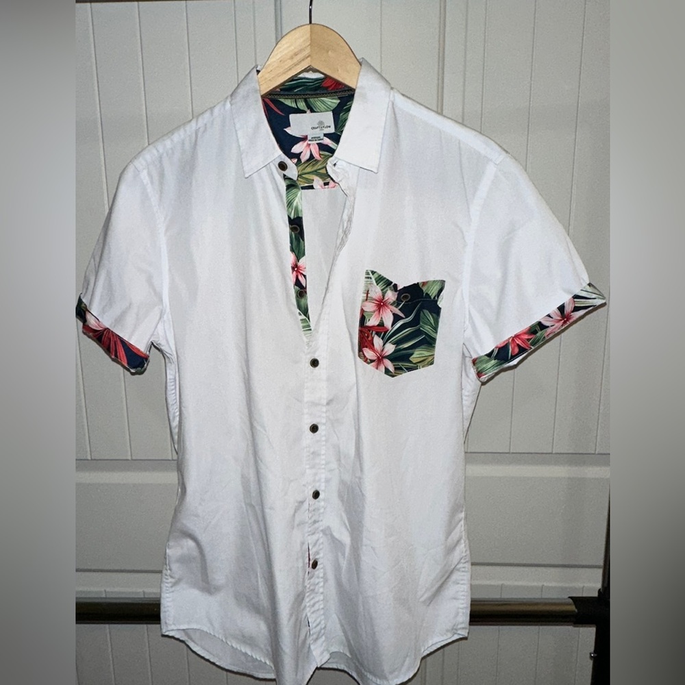 White short sleeve button down with Hawaiian pattern accents.